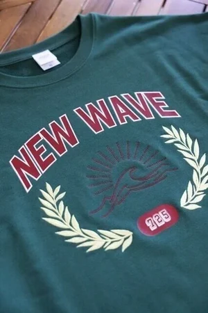 「NEW WAVE」の文字と月桂樹をプリントした緑のTシャツ