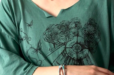 首元が切りっぱなしの加工、胸元に細かいスクリーンプリントが施されたグリーンのTシャツ