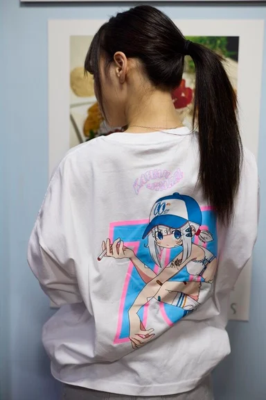白いロングスリーブTシャツの後ろ姿。背面にキャップをかぶった少女のイラスト