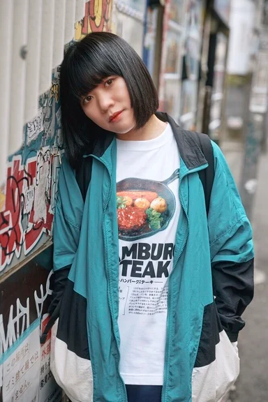 路地に立つモデル。ハンバーグステーキのレシピを写真でプリントした白Tシャツ