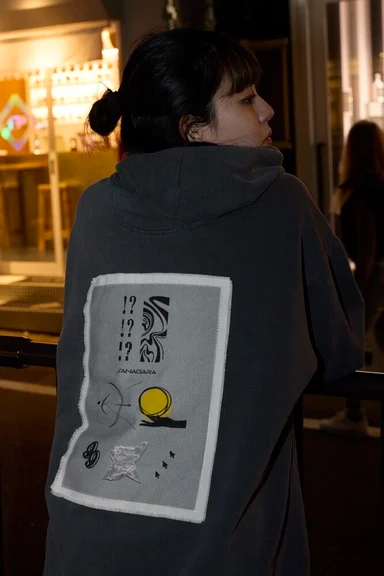チャコールのパーカーの後ろ姿。背中に大きな布パッチを縫い付けている
