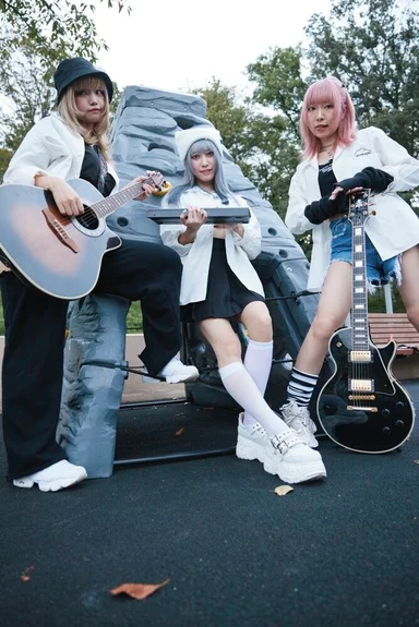 公園で楽器を持つ3人。おそろいの白いシャツ