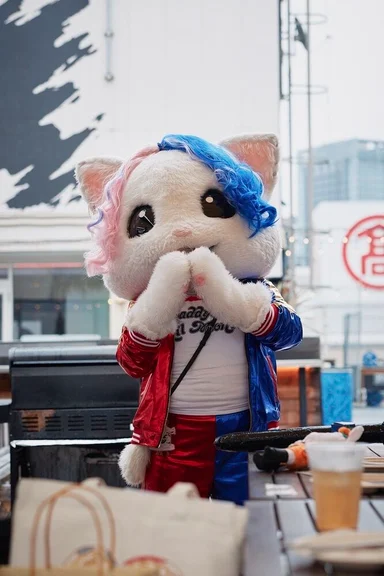 赤と青のジャケットを着た猫の着ぐるみ