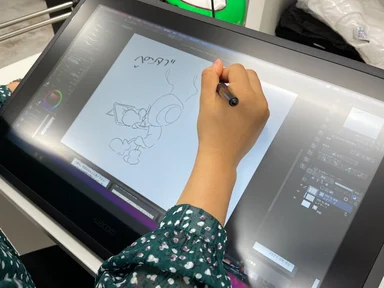 ペンタブレットでアント君のイラストを描いているスタッフ