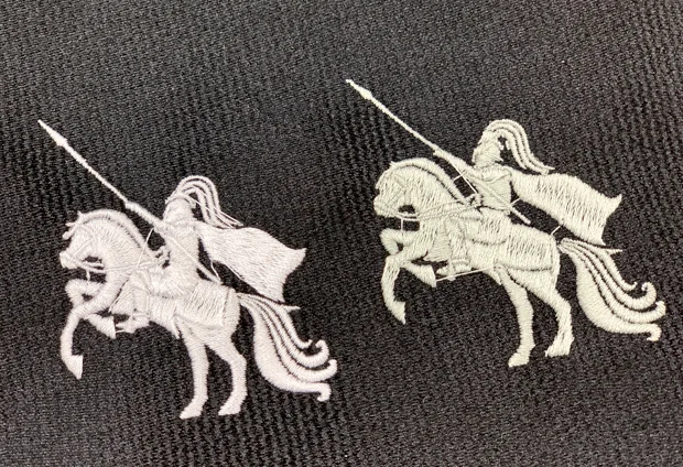 黒い生地に、馬に乗る騎士の図柄を薄いグレーの糸で刺繍した比較。左は目が詰まっていて表面がなめらか、右は目が粗く縫い目が見える仕上がり