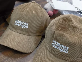 ベージュのコーデュロイの帽子2つに、白い糸で「HOROYOI Chanqoo」のロゴを刺繍したもの