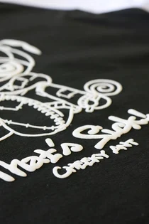 黒いTシャツに白い発泡インクで刷った「That's Sick!」の文字とキャラクターの寄り。インクがふっくら盛り上がっている